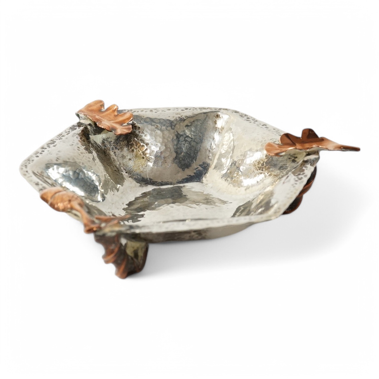 A 20th century Arts & Crafts planished white metal hexagonal dish, mounted with copper acorn and leaf surmounts, in the manner of Gorham & Co, diameter 12.8cm, gross weight 5.78oz. Condition - fair to good